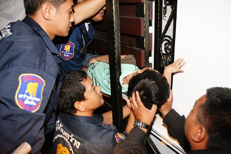 Rescue workers support the boy whilst freeing him from being trapped in the gate.